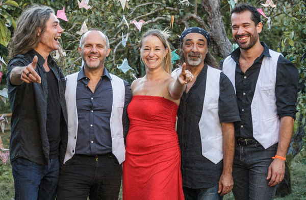Five piece pop rock band in France posing for picture alongside one another prior to outdoor performance | Altus Entertainment