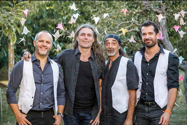Male musicians for pop rock band in France smiling to camera happily before outdoor wedding reception | Altus Entertainment