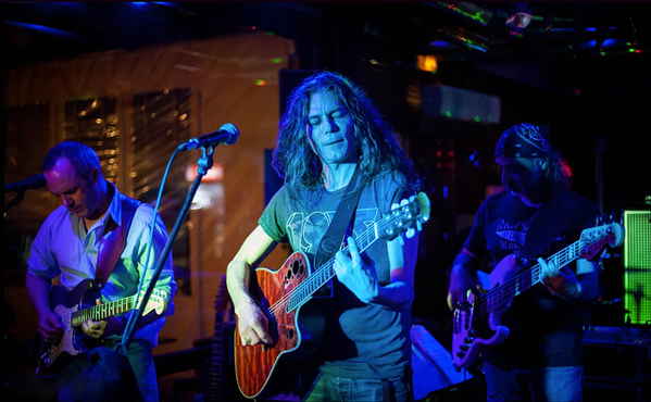 Wide angled picture of musicians in pop rock band in France passionately playing instruments alongside each other | Altus Entertainment