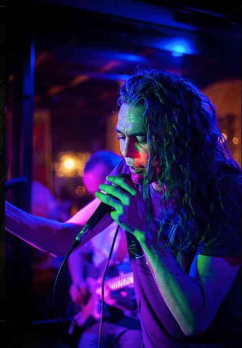 Promotional picture of lead male cover singer looking down to audience from stage while performing | Altus Entertainment