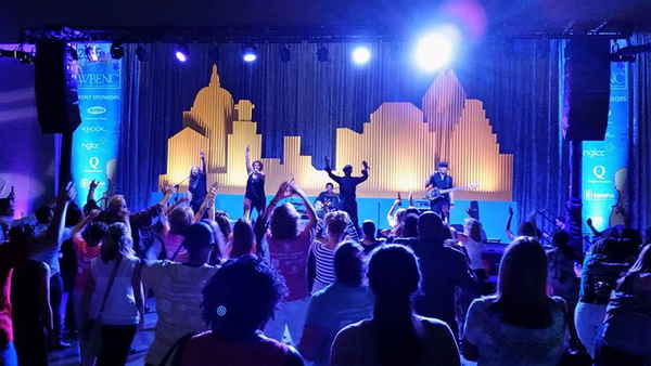 Texas variety cover band performing in front of city scape props onstage during corporate conference | Altus Entertainment
