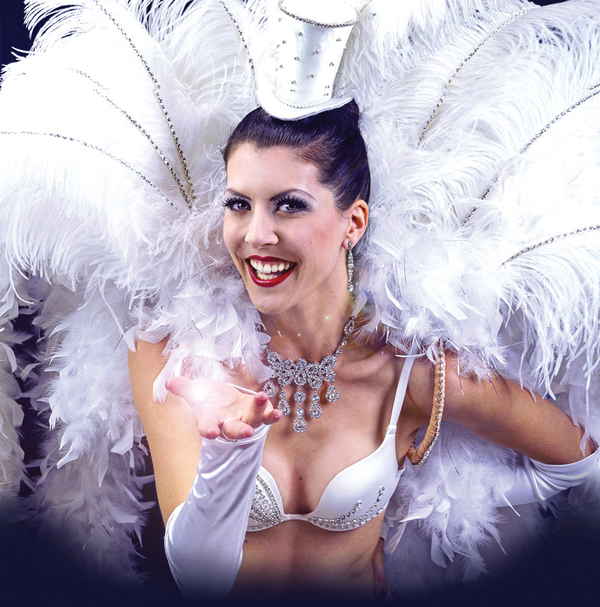 Promotional photo of female dancer in French cabaret show adorned in all white costuming while blowing kiss to camera | Altus Entertainment