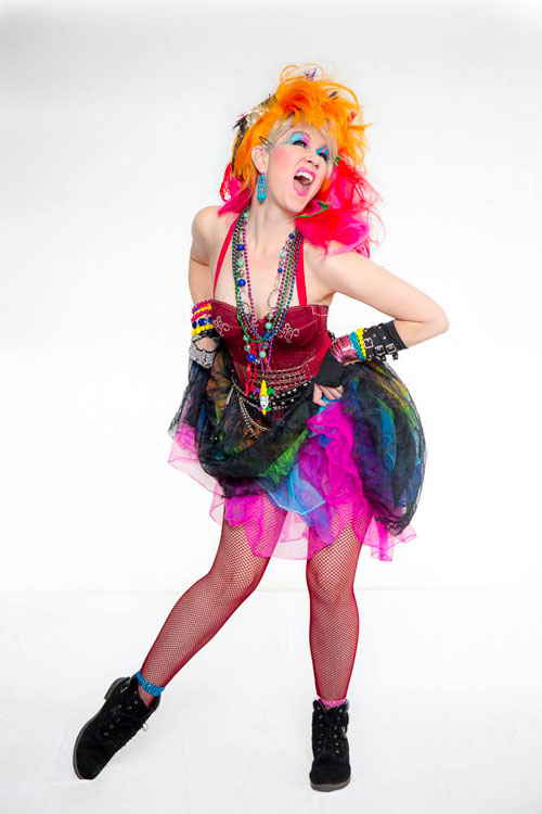 Professional photoshoot of our female Cyndi Lauper impersonator looking to sky and dancing with hands on hips | Altus Entertainment