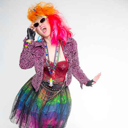 Female Cyndi Lauper impersonator holding sunglasses on faces while dynamic dancing during photoshoot | Altus Entertainment