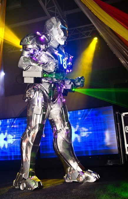 Silver color robotic performer walking onstage while shining bright green LED lasers during robot laser show in Malta | Altus Entertainment