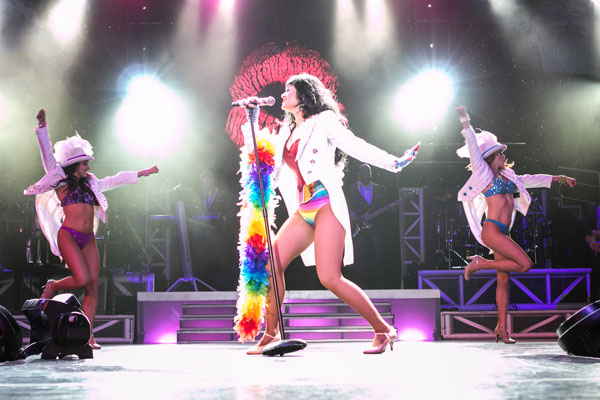 Katy Perry impersonator singing center stage under bright stage light as two dancers are behind her | Altus Entertainment