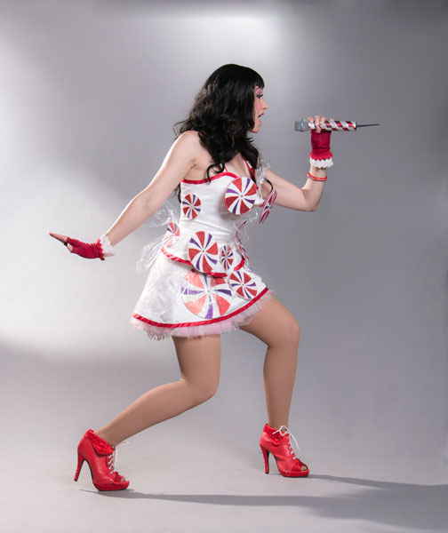Katy Perry impersonator singing into microphone while wearing white and red peppermint themed costume | Altus Entertainment