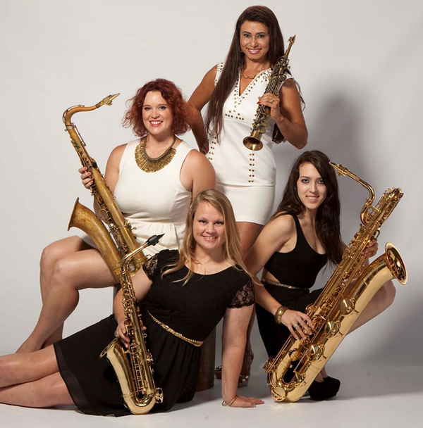 Two female horn musicians wearing black dresses and two female horn players wearing white dresses sitting in all white room for picture | Altus Entertainment