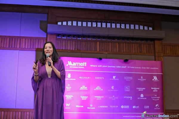 Event emcee in Thailand wearing dark purple flowy dress while MCing corporate event | Altus Entertainment