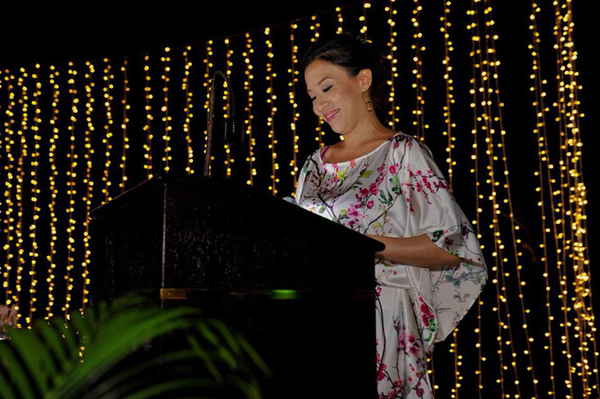 Low angled picture of female event emcee in Thailand standing at podium while hosting event | Altus Entertainment