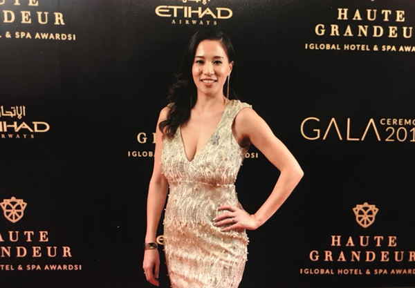 Female event emcee in Thailand adorned in gold formal dress posing for picture on red carpet event | Altus Entertainment